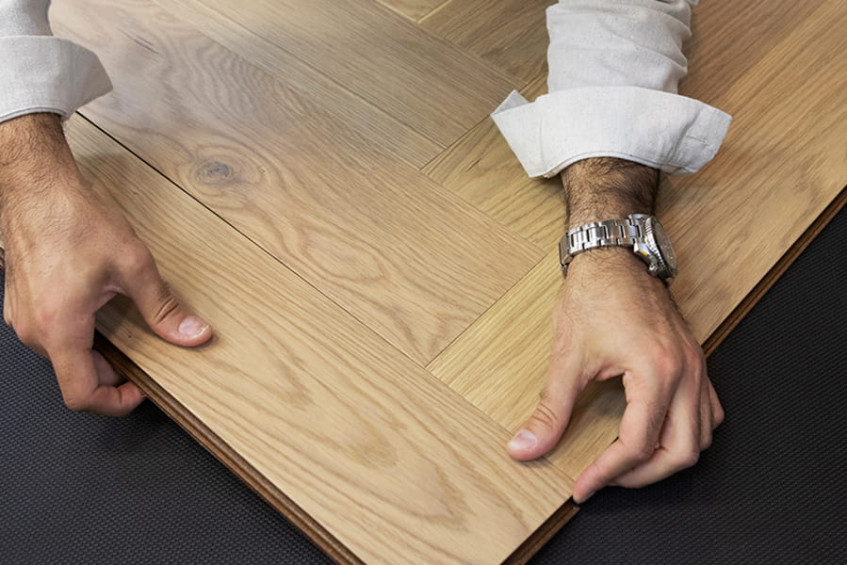 Демонстрация монтажа Oak Amalfi HB, руки соединяют плашки в укладку елочка