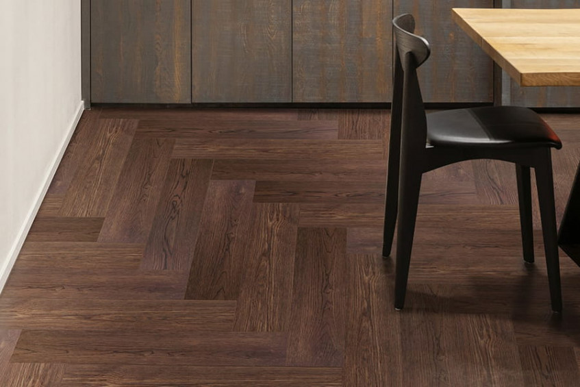 Интерьер с паркетным полом AUSWOOD Oak Rodos HB — дуб тёмный, укладка «ёлочка», зона у стула