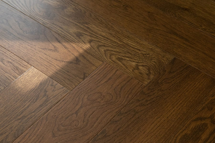 Oak Rodos HB в интерьере — тёмная «ёлочка», блики солнечного света на матовой поверхности паркетной доски