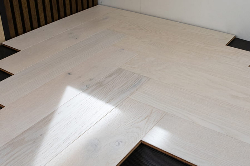 Oak Elba HB «ёлочка» у ступени/подиума — светлый дубовый пол, ракурс под углом