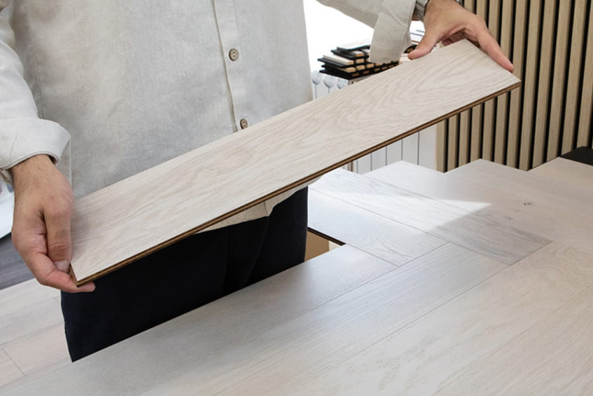 Монтаж паркетной доски Oak Elba HB — мастер держит плашку паркетной доски, показывая укладку «ёлочка», инженерная доска AUSWOOD